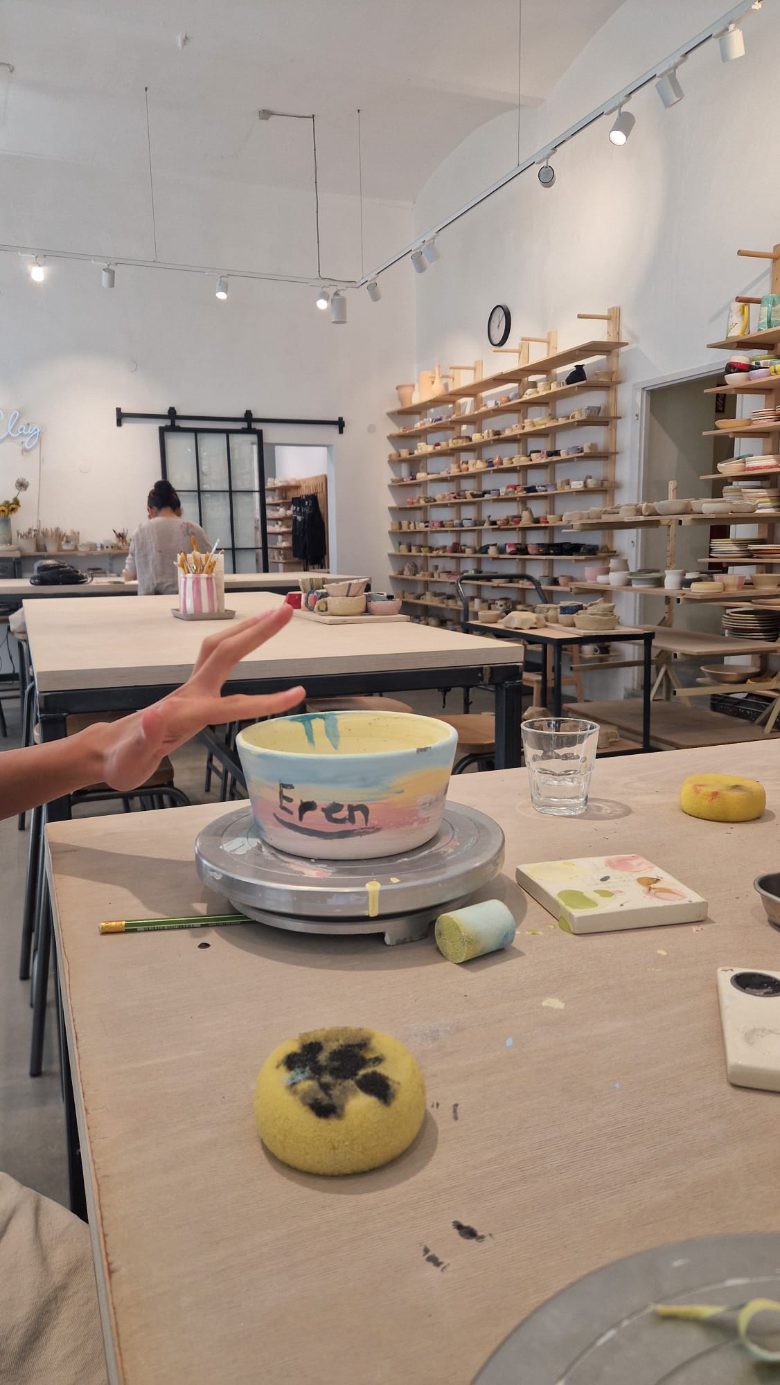 Helles Keramik-Studio von Fresh Ceramics in Wien mit Regalen voller Geschirr und einer bunt bemalten Schale