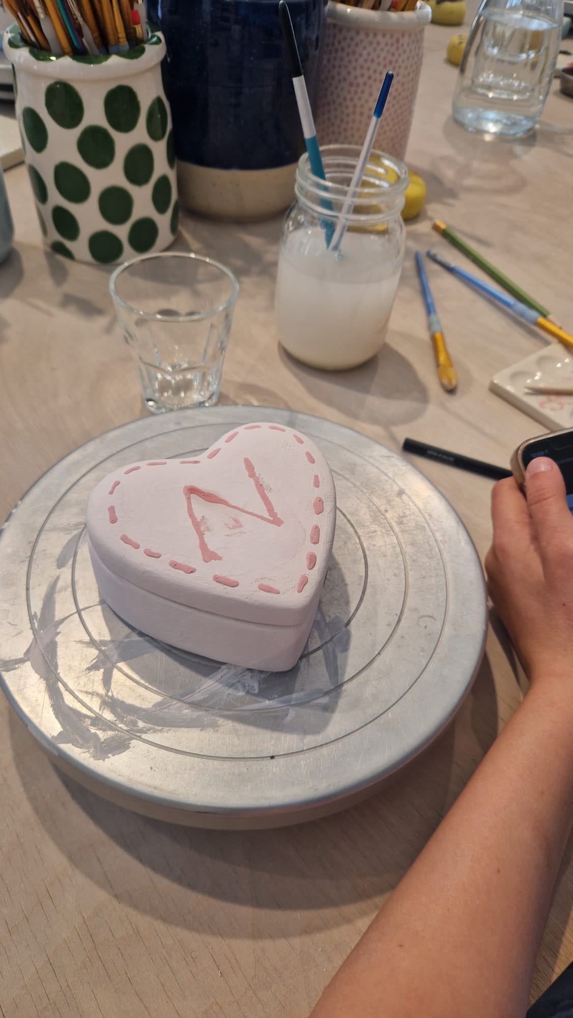 Herzförmige Keramikdose mit dem Buchstaben N wird in Rosa bemalt