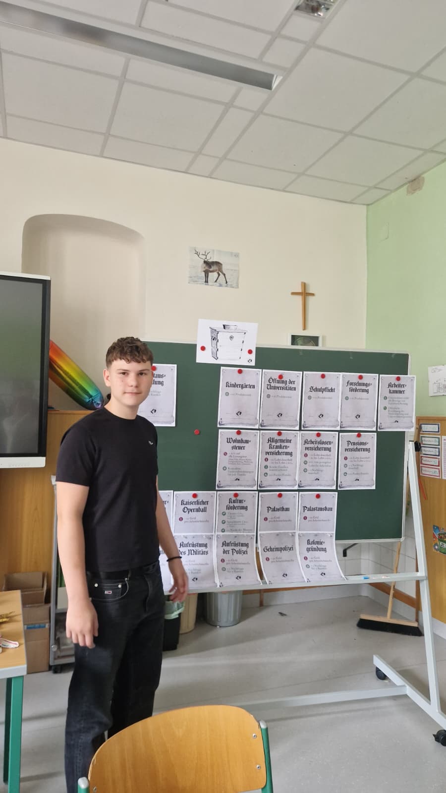 Schüler der PTS Ebreichsdorf steht vor der Tafel mit den Gesetzeskarten des Planspiels Sozialstaat